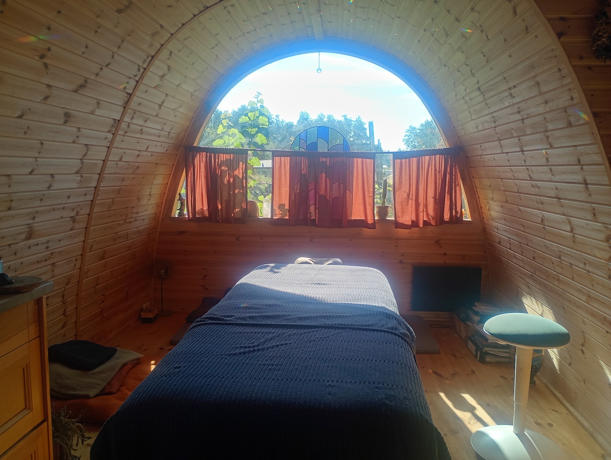 Houten behandelruimte met gebogen plafond en massagetafel